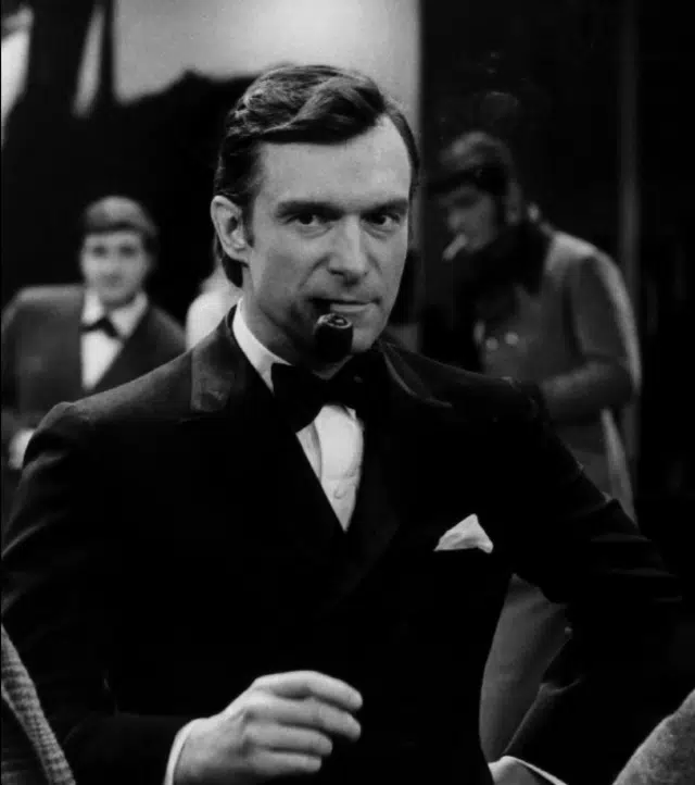 Hugh Hefner dans Playboy After Dark, recadré à partir de l'image promotionnelle originale - Playboy Enterprises | Domaine public.