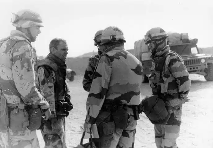 Le colonel Ronald Francis Rokosz (commandant de la 2e brigade de la 82e division aéroportée, sans casque) s'entretient avec une équipe de liaison de la 6e division blindée légère française dans des positions de rassemblement tactique près de Rafha, dans la province du nord de l'Arabie saoudite, le 23 février 1991, la veille du début de l'offensive terrestre - Dennis P. Levin | XVIIIe Corps aéroporté, photographie DS-F-317-11A
