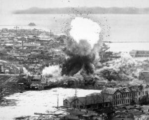 Les entrepôts d'approvisionnement et les installations portuaires de cet important port de la côte Est subissent les bombes larguées par les bombardiers légers B-26 Invader de la Cinquième armée de l'air. Wonsan, Corée du Nord. Armée de l'air : vers 1951 - USAF | Domaine public