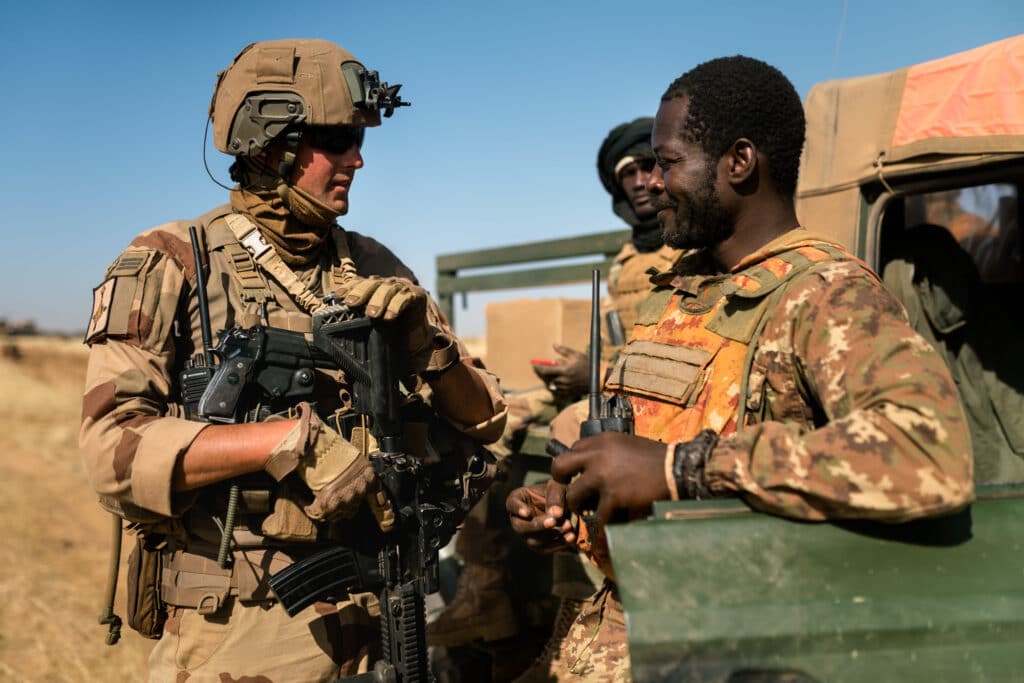 Un officier français avec un treillis F2 camouflage Daguet discute avec un soldat malien lors de l'opération franco-malienne Éclipse (Opération Barkhane / Guerre du Mali) - Éric B | Licence Ouverte 2.0