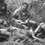 Patrice Le Nepvou de Carfort, médecin du 8e bataillon colonial de parachutistes (armée française), prodigue les premiers soins à un parachutiste vietnamien (combattant aux côtés des Français) blessé sur la piste de Pavie lors de la bataille de Diên Biên Phu en Indochine - Rundvald | Domaine public