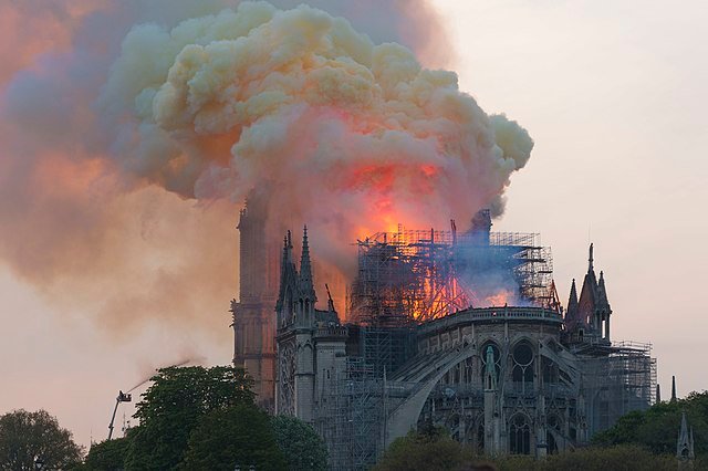 À intervalles relativement réguliers, l'incendie s'intensifie, avec de brusques bouffées de flammes triplant de hauteur et dégageant une fumée jaune, lors du feu de la cathédrale Notre-Dame de Paris - GodefroyParis [Pseudo Wikipédia] | Creative Commons BY-SA 4.0