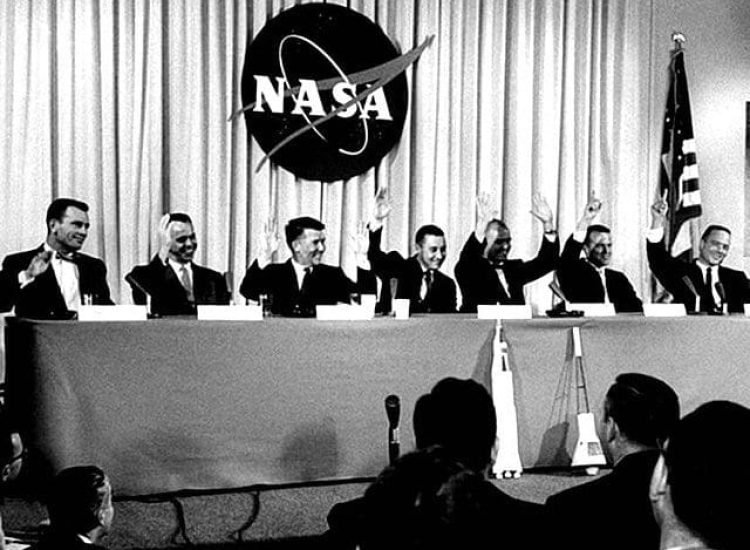 Lors de la conférence de presse du 9 avril 1959 qui a présenté les astronautes de la mission Mercury, la question suivante leur a été posée : "Qui veut être le premier homme lancé dans l'espace ?" Les sept hommes ont levé la main, Walter Schirra et John Glenn ayant levé les deux mains. De gauche à droite, Donald Slayton, Alan Shepard, Schirra, Gus Grissom, Glenn, Gordon Cooper et Scott Carpenter. | Domaine public.