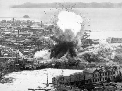 Les entrepôts d'approvisionnement et les installations portuaires de cet important port de la côte Est subissent les bombes larguées par les bombardiers légers B-26 Invader de la Cinquième armée de l'air. Wonsan, Corée du Nord. Armée de l'air : vers 1951 - USAF | Domaine public