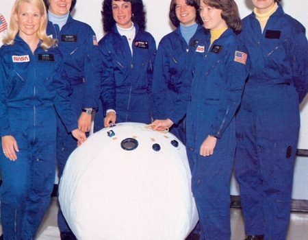 Les six premières femmes astronautes de la NASA posent avec une maquette d'enceinte de sauvetage personnelle (PRE) ou "ballon de sauvetage" dans le laboratoire des systèmes d'équipage du Centre spatial Johnson. De gauche à droite, Margaret R. (Rhea) Seddon, Kathryn D. Sullivan, Judith A. Resnik, Sally K. Ride, Anna L. Fisher et Shannon W. Lucid. 1980. | Domaine public.