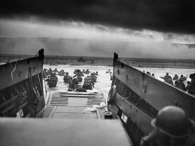 Dans les mâchoires de la mort. Un LCVP (Landing Craft, Vehicle, Personnel) des garde-côtes américain débarque des troupes de la Compagnie A, 16e Infanterie, 1re Division d'Infanterie qui pataugent sur la section Fox Green d'Omaha Beach (Calvados, Basse-Normandie, France) dans la matinée du 6 juin 1944. Lors du débarquement, les soldats américains se heurtèrent à la 352e division allemande nouvellement formée. Au cours du débarquement initial, les deux tiers de la compagnie E furent blessés - Chief Photographer's Mate (CPHoM) Robert F. Sargent | Domaine public