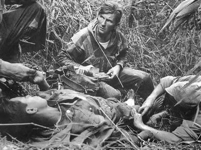 Patrice Le Nepvou de Carfort, médecin du 8e bataillon colonial de parachutistes (armée française), prodigue les premiers soins à un parachutiste vietnamien (combattant aux côtés des Français) blessé sur la piste de Pavie lors de la bataille de Diên Biên Phu en Indochine - Rundvald | Domaine public