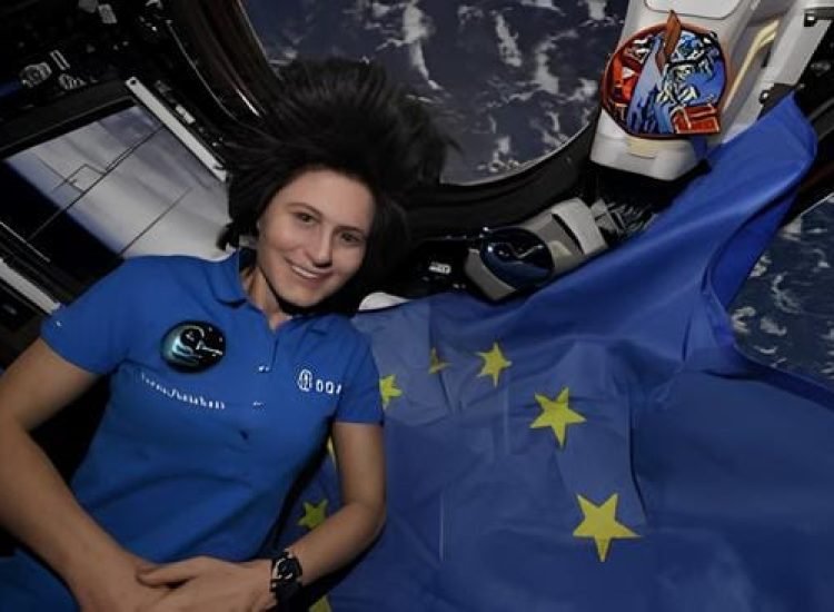 L'astronaute de l'ESA Samantha Cristoforetti dans la coupole à sept fenêtres, la « fenêtre sur le monde » de la Station spatiale internationale, avec le drapeau de l'UE - Samantha Cristoforetti | Creative Commons BY-NC-SA 4.0