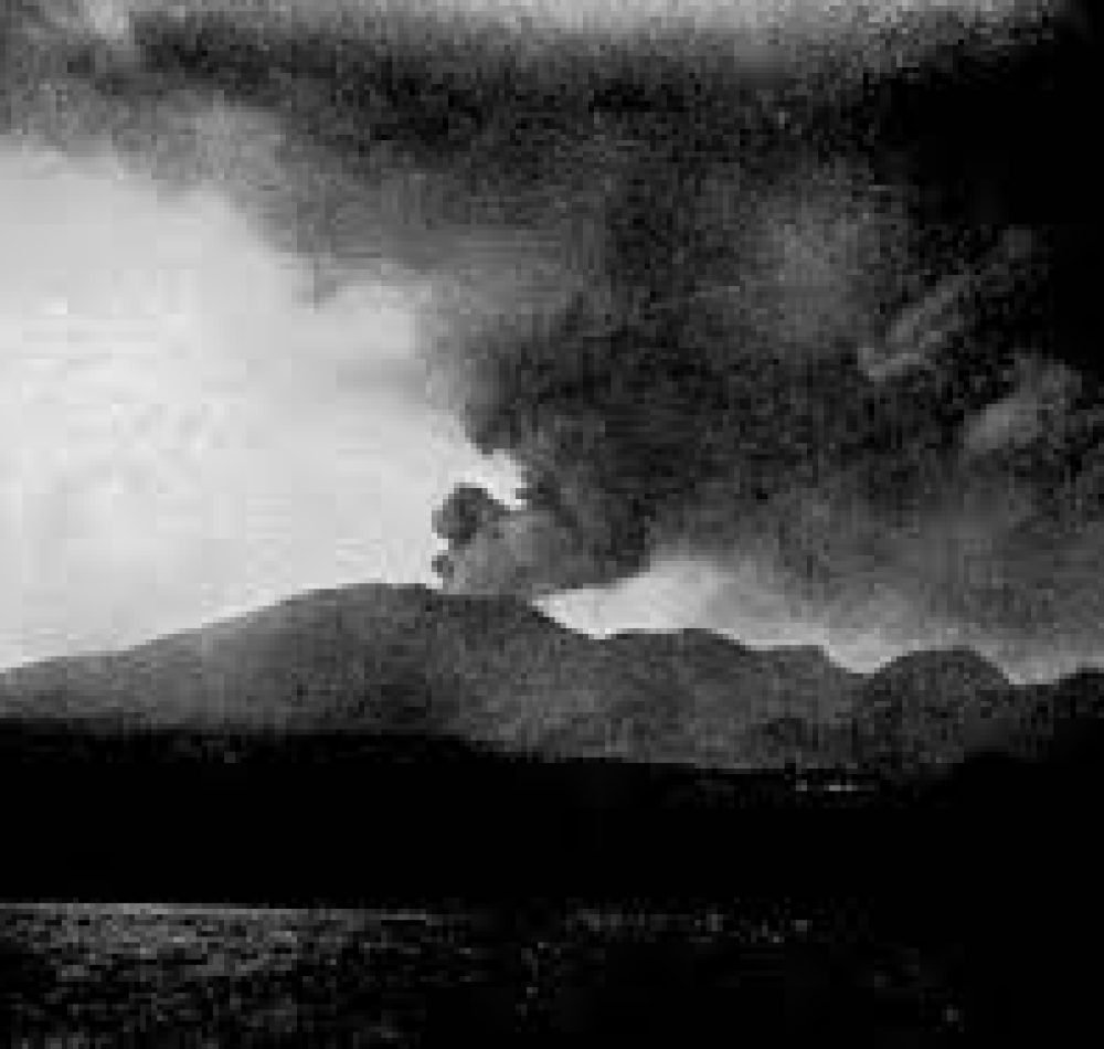 Photo en noir et blanc de la montagne Pelée crachant de la fumée en 1902 - Domaine public