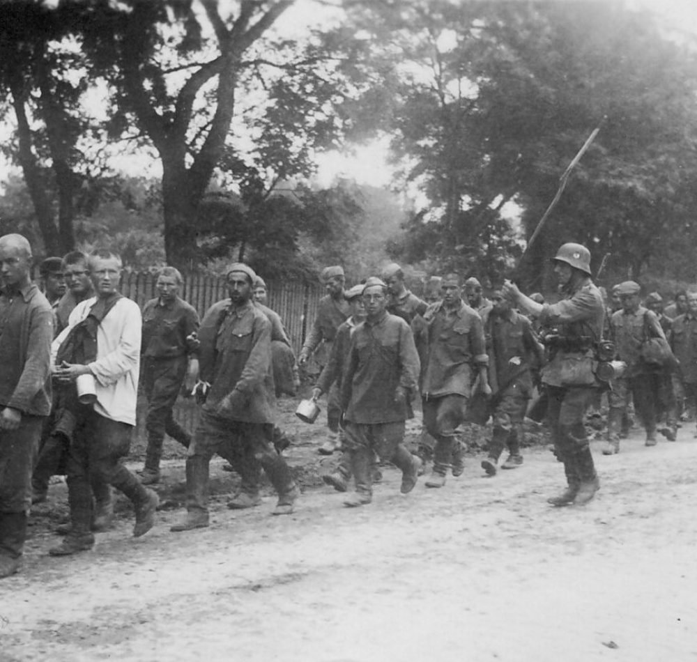 Prisonniers de guerre russes menés vers un camp de concentration par un soldat allemand. Plus des trois quarts des 4 millions de prisonniers de guerre soviétiques mourront de faim et de maladie - Probablement une photo prise par les Allemands et acquise par la suite par la cellule de documentation de l'Armia Krajowa | Domaine public
